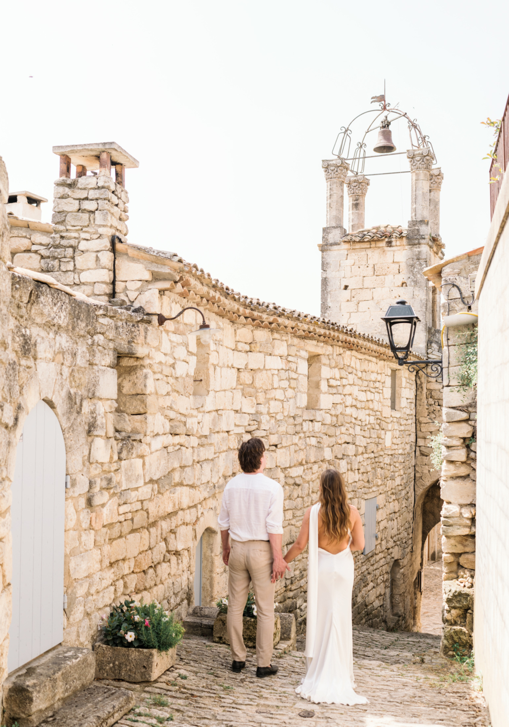 bride and groom admire old village in lacoste france