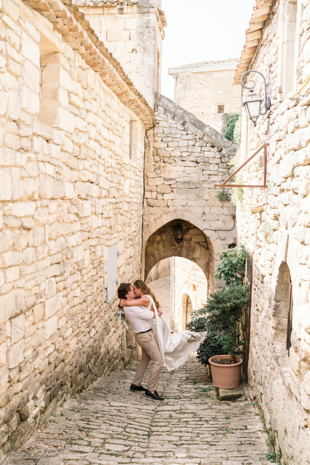 groom lifts bride in lacoste france