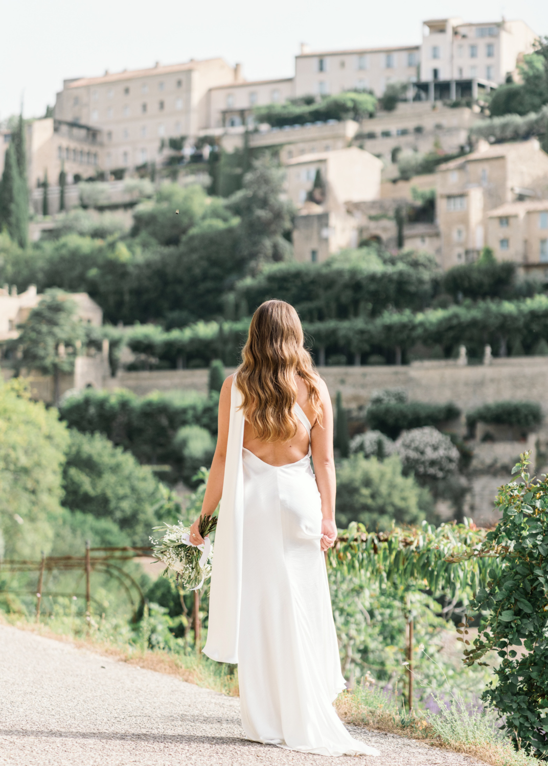 bride poses looking at old town in gordes france