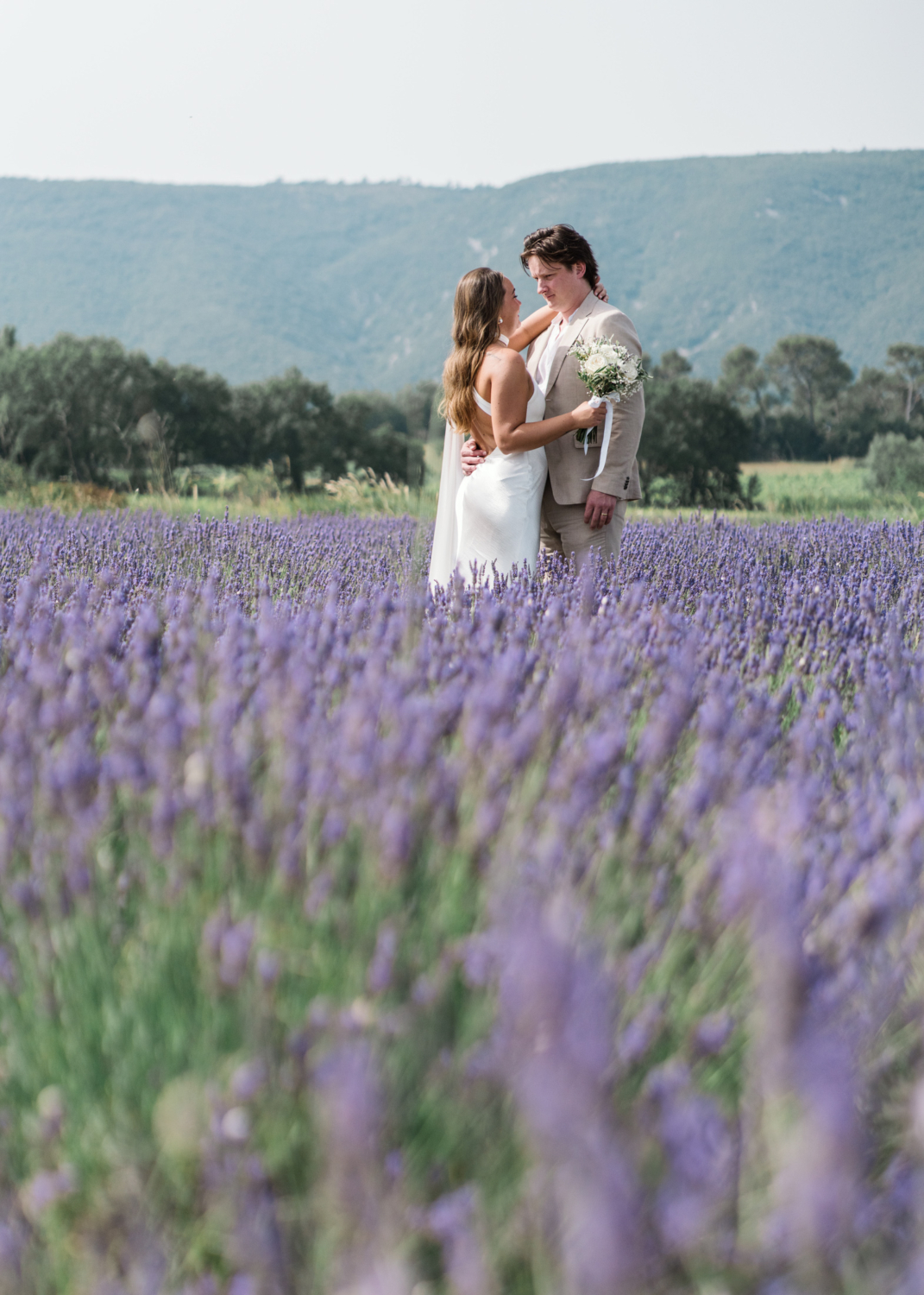 bride and groom embrace in lavender fields in provence france