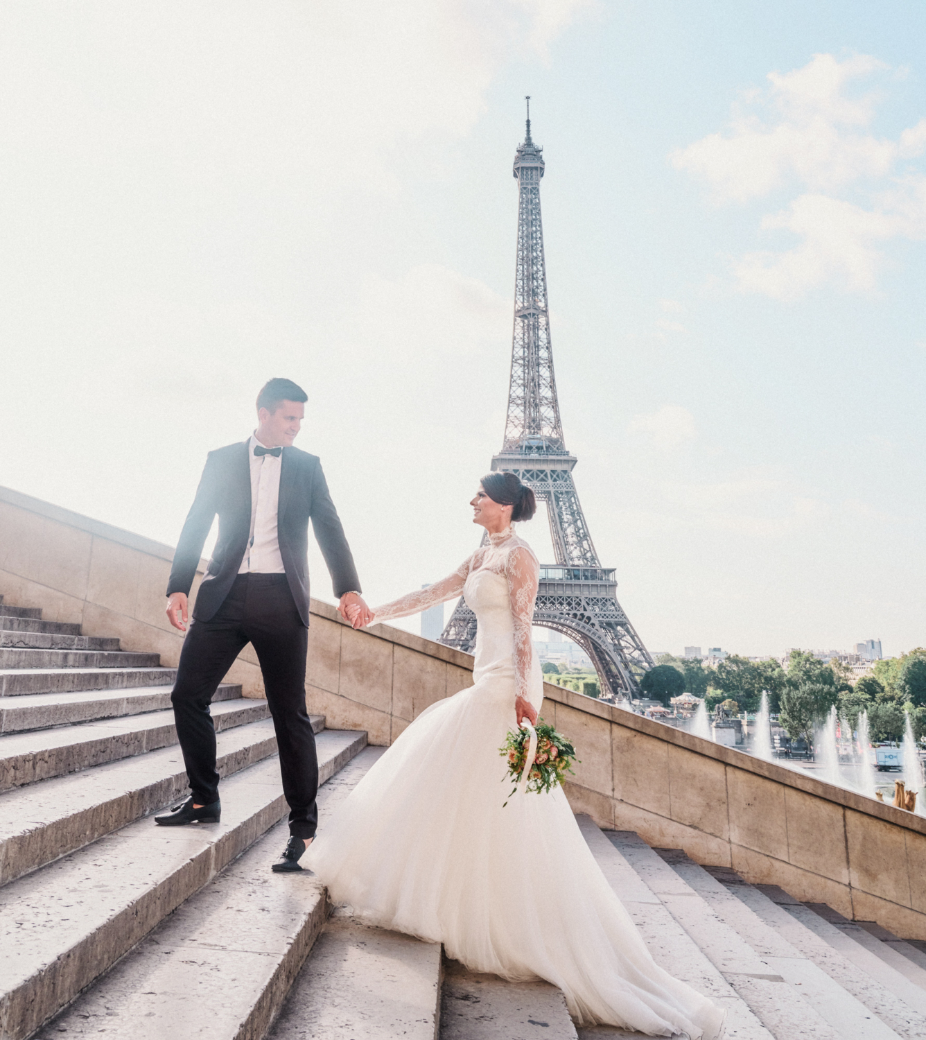 bride and groom walk up staircase at eiffel tower paris