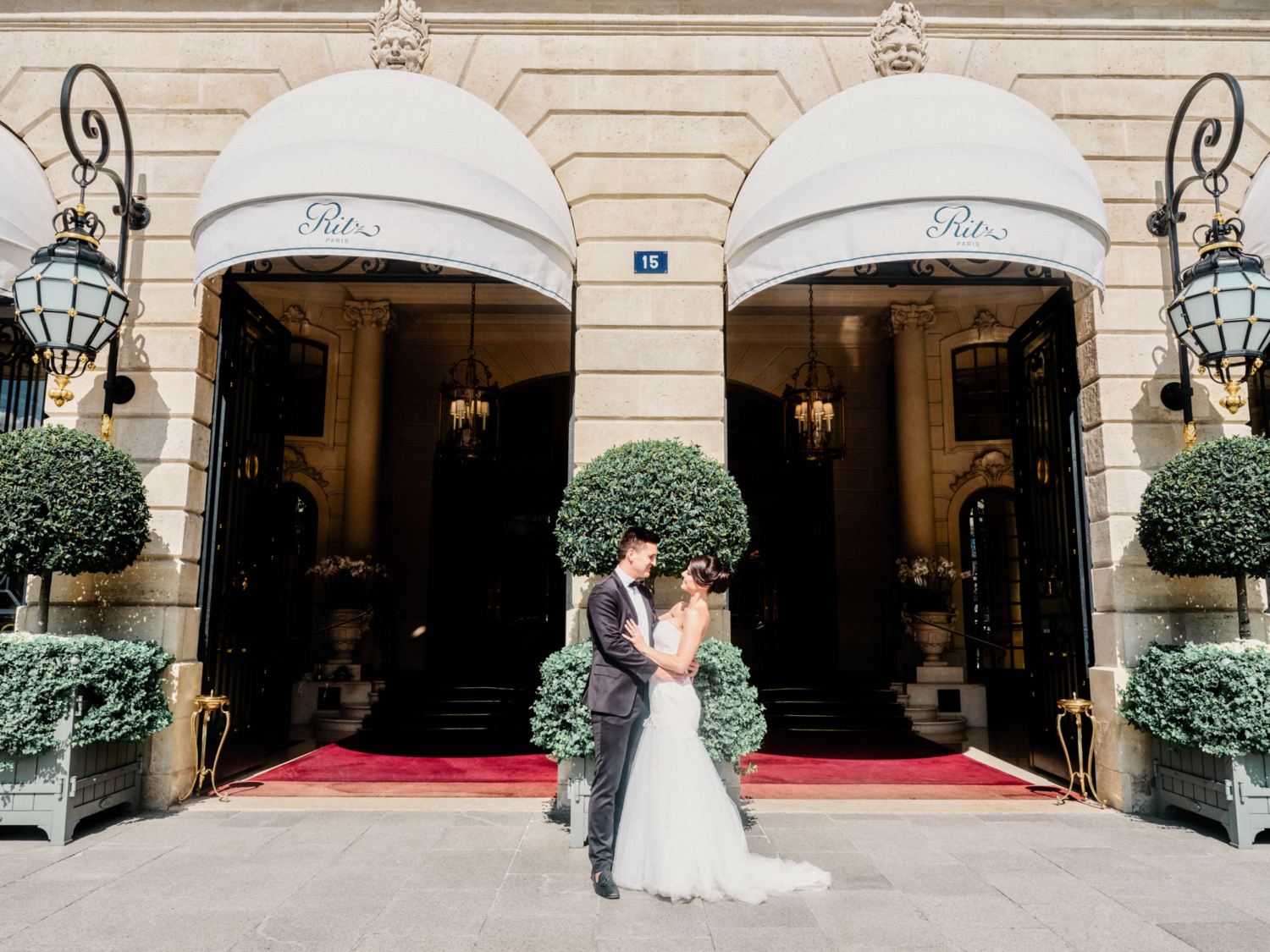 bride and groom pose outside ritz hotel paris