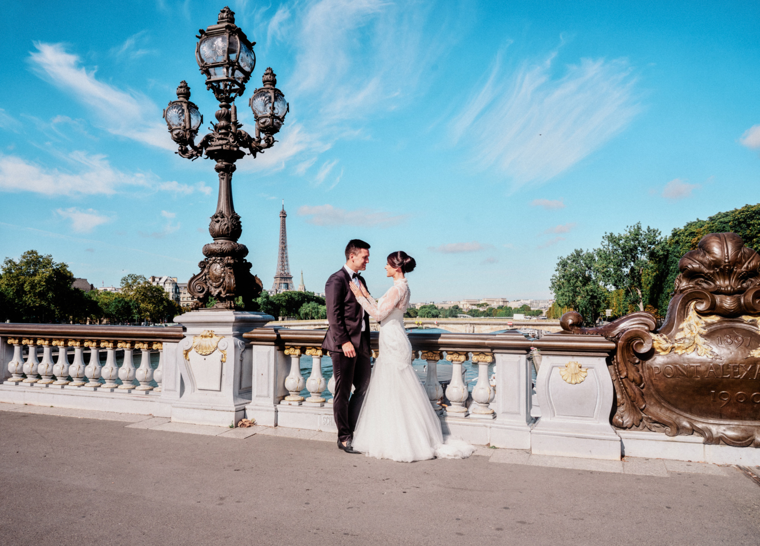 bride and groom pose on pont alexandre in paris france