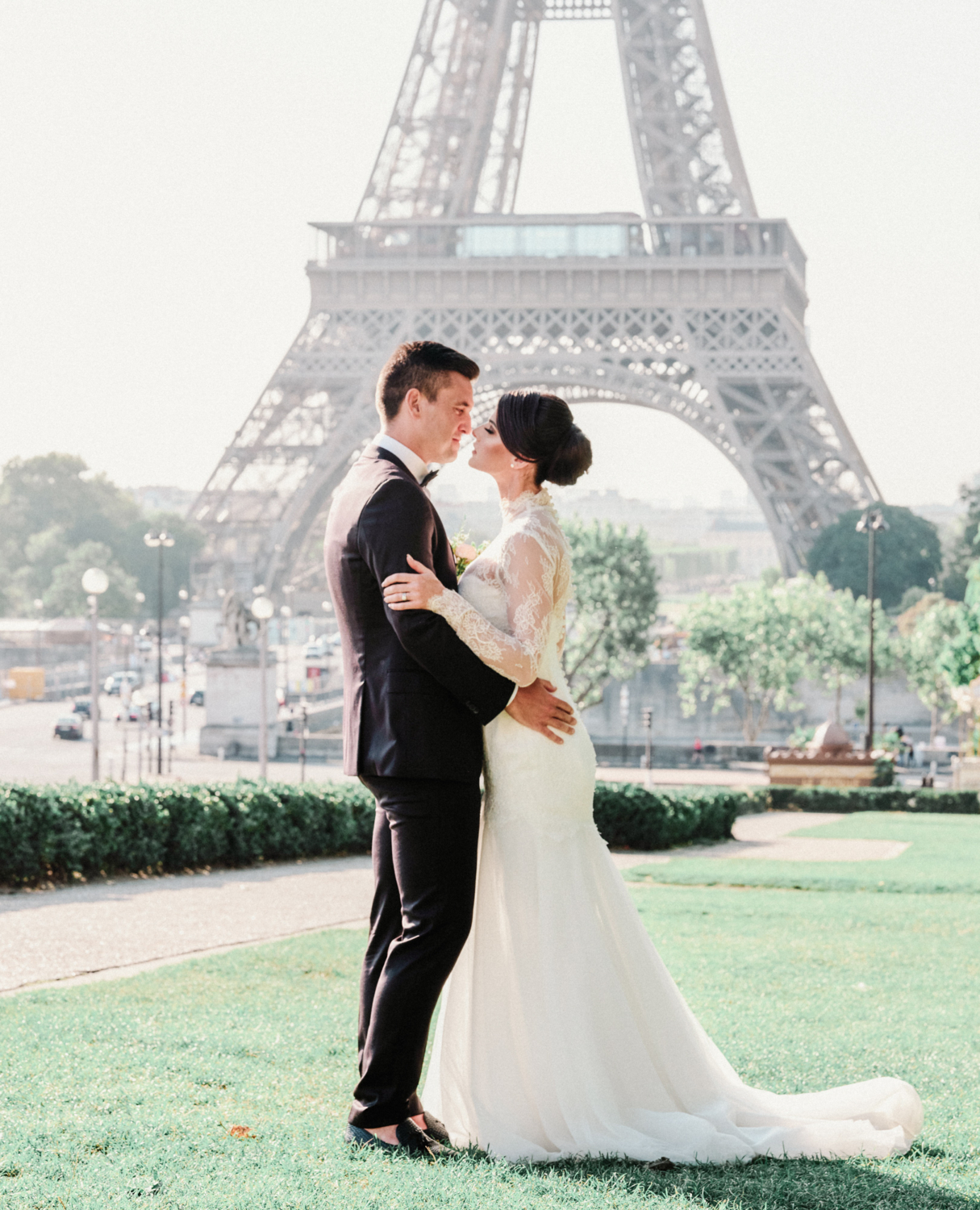 bride and groom embrace at eiffel tower paris