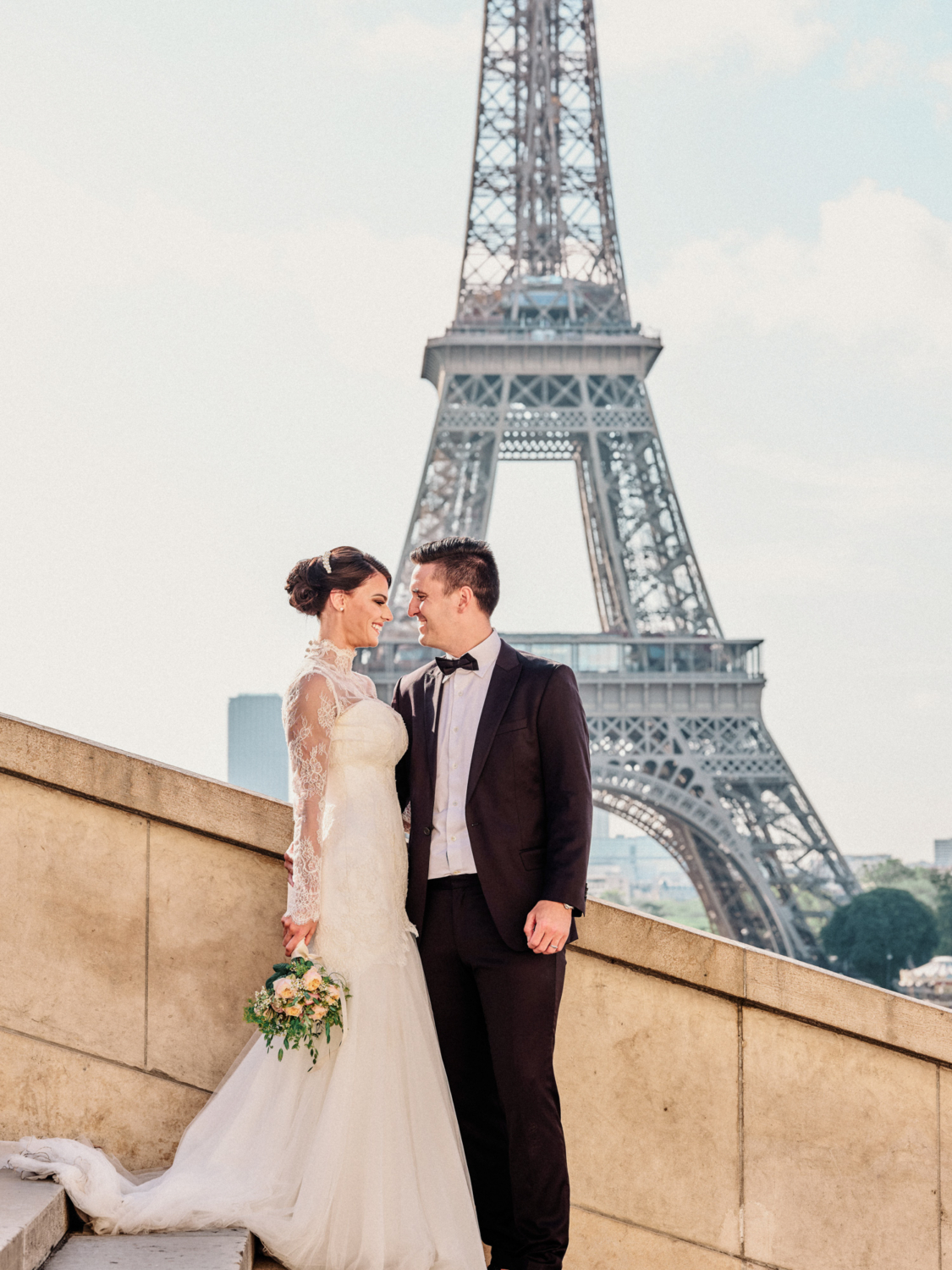 bride and groom pose at eiffel tower paris france