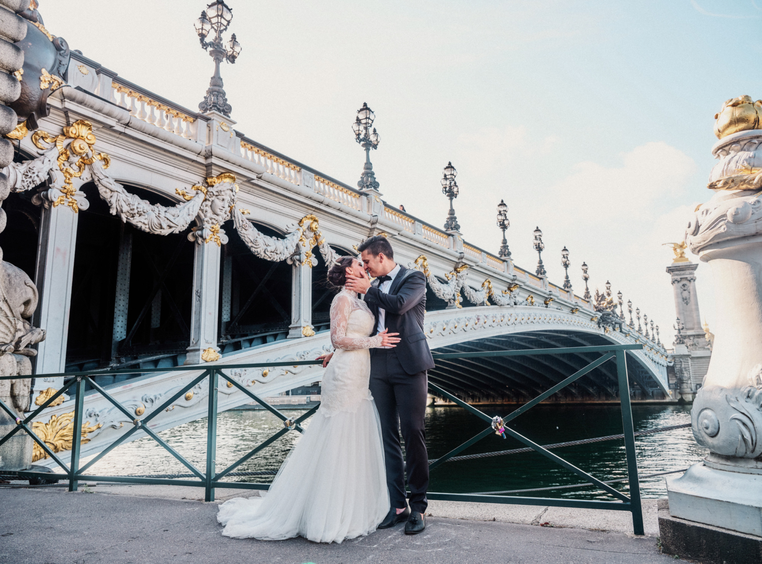 bride and groom kiss under pont alexandre in paris