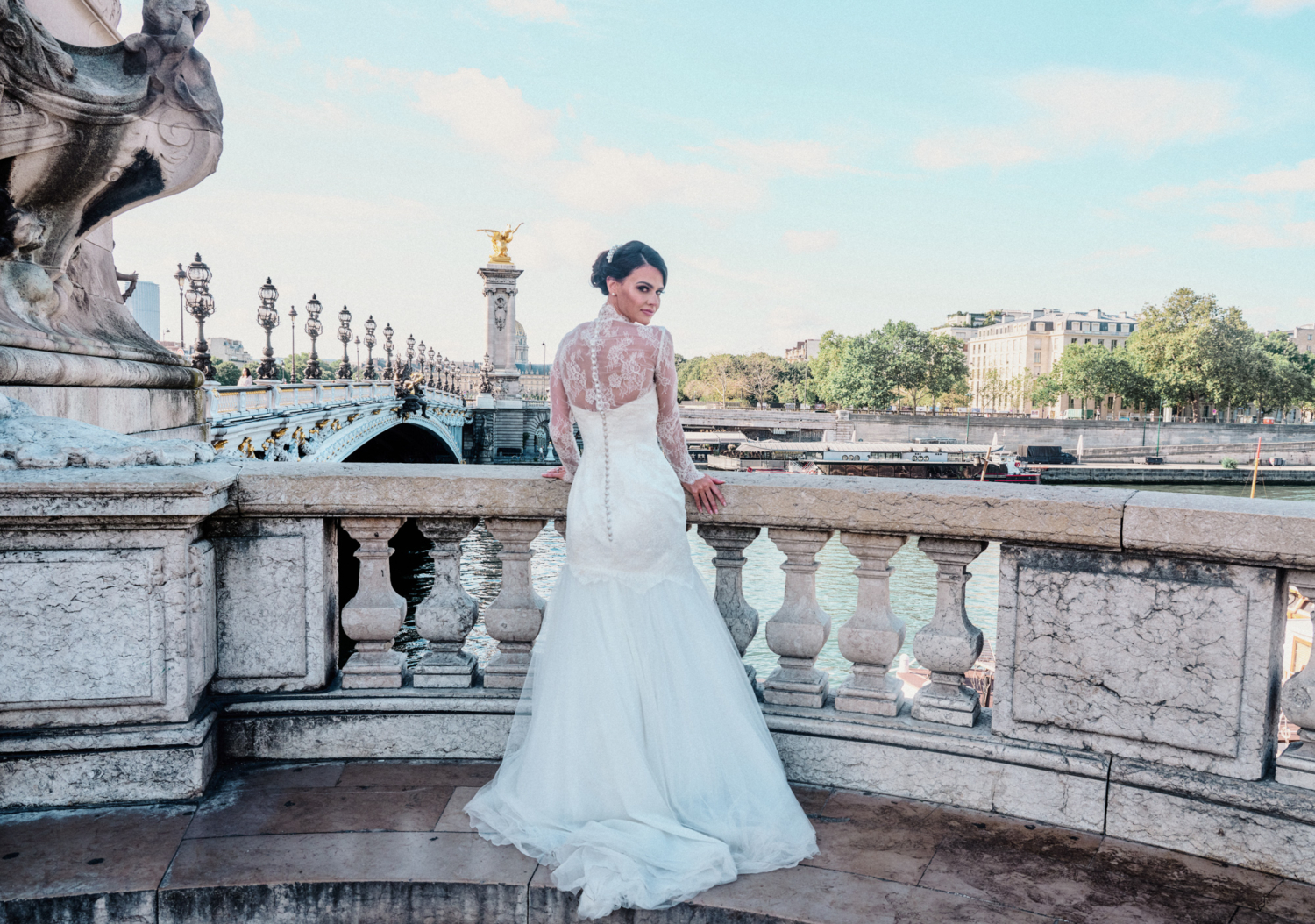 stunning bride poses in wedding gown on pont alexandre paris