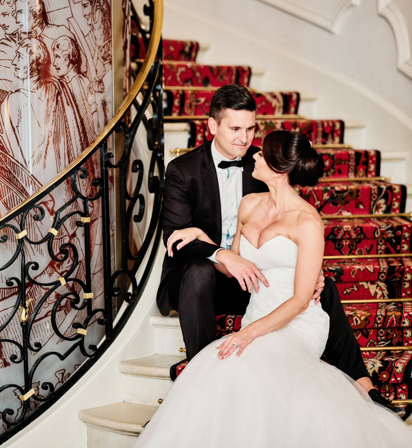 bride and groom pose on staircase at ritz hotel paris