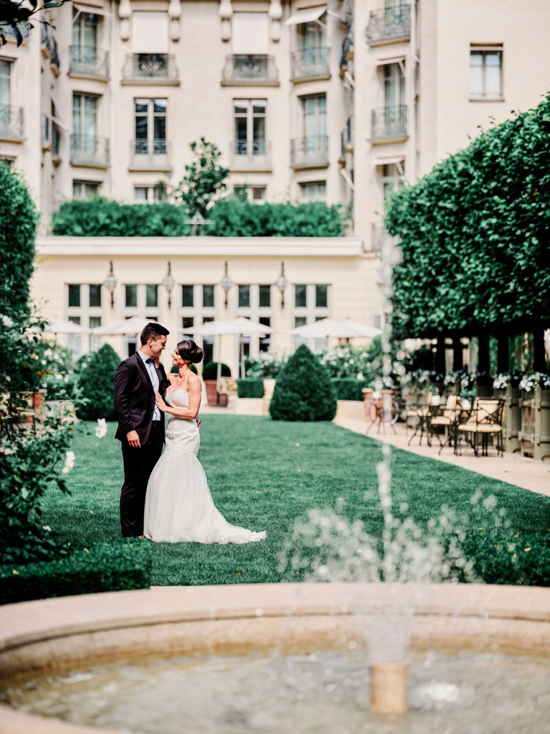 bride and groom pose in garden at ritz hotel paris