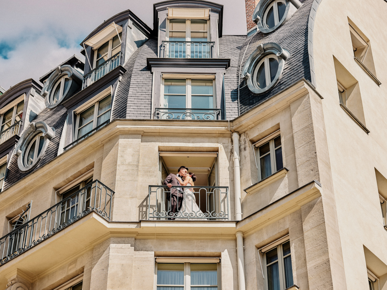 bride and groom kiss on balcony at ritz hotel paris