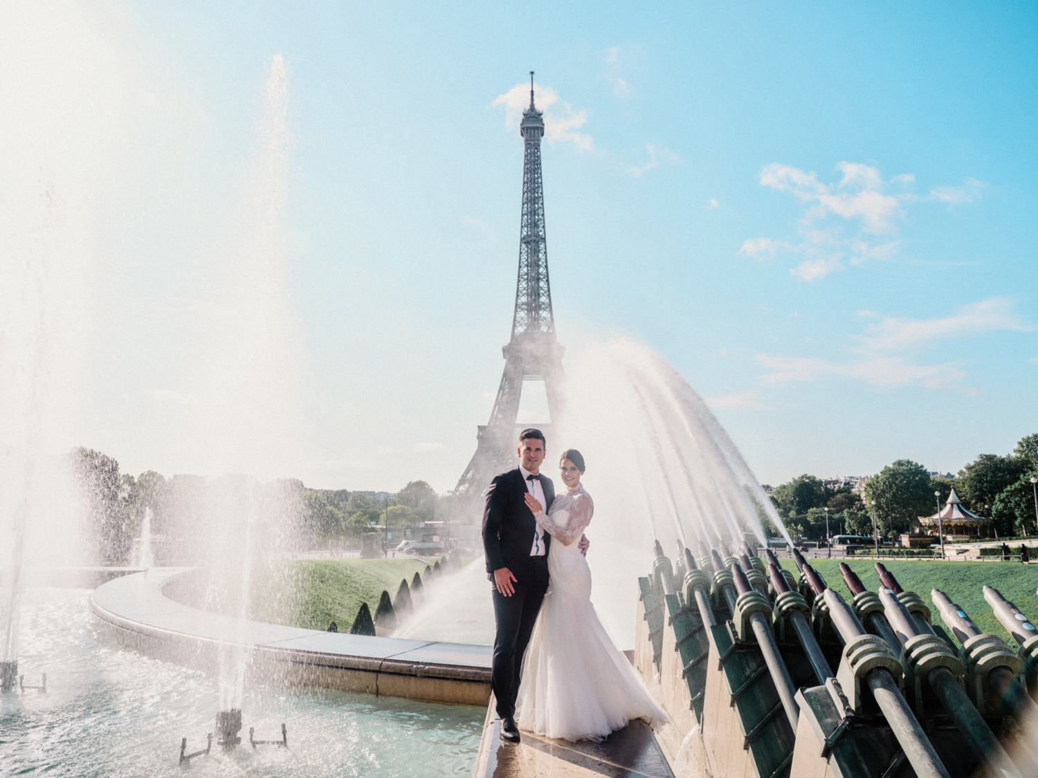 bride and groom pose in front of fountains at eiffel tower paris