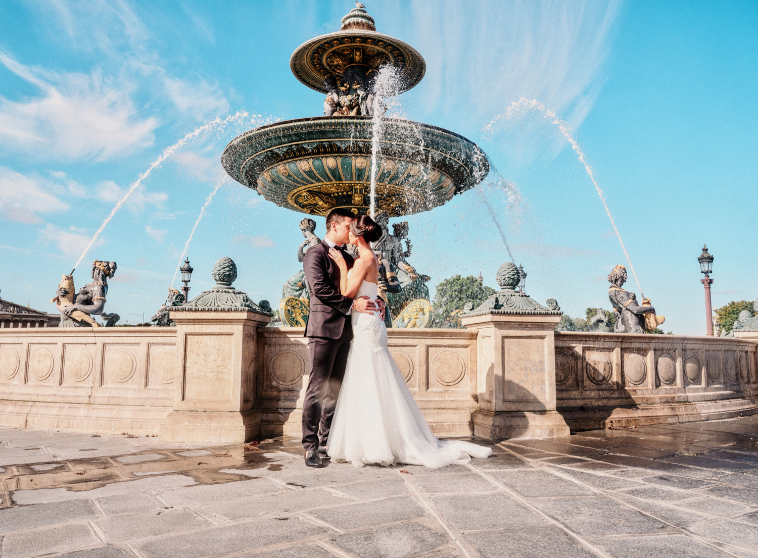 bride and groom embrace and kiss at place de la concorde paris