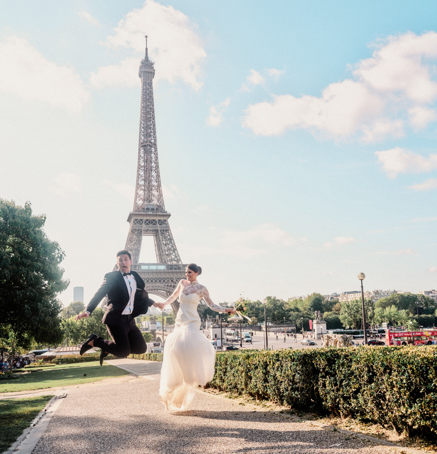 bride and groom jump in air at eiffel tower paris