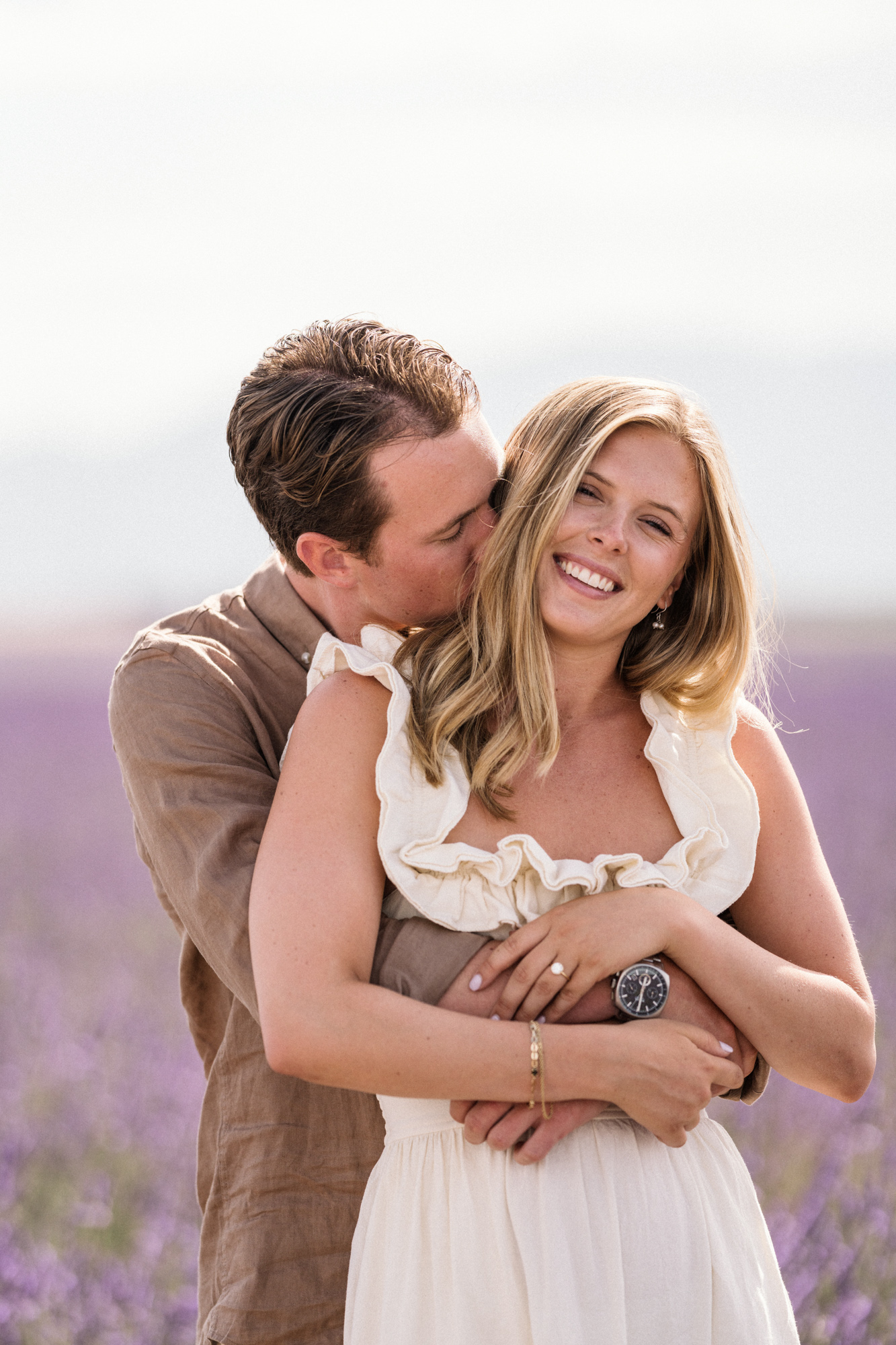 man kisses woman on the side of neck