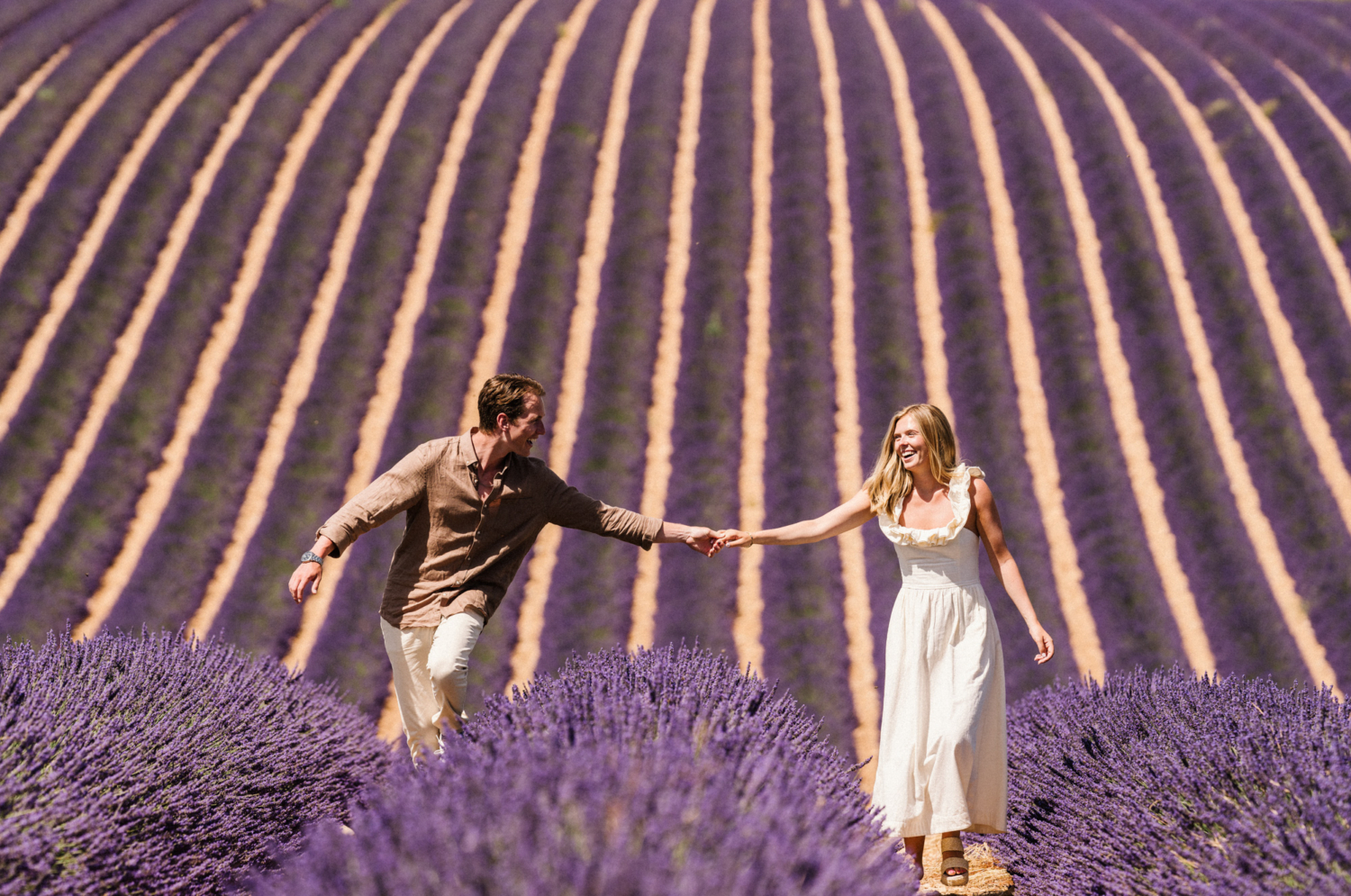 couple walk and laugh in a lavender field in provence