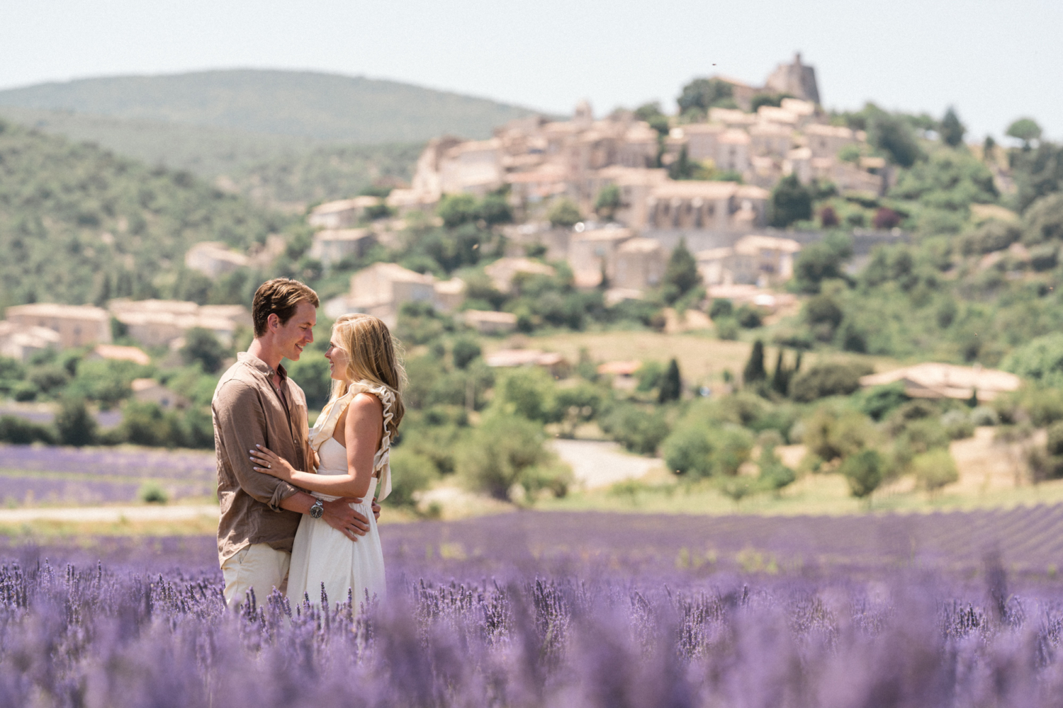 man wraps arm around woman's waist in lavender field