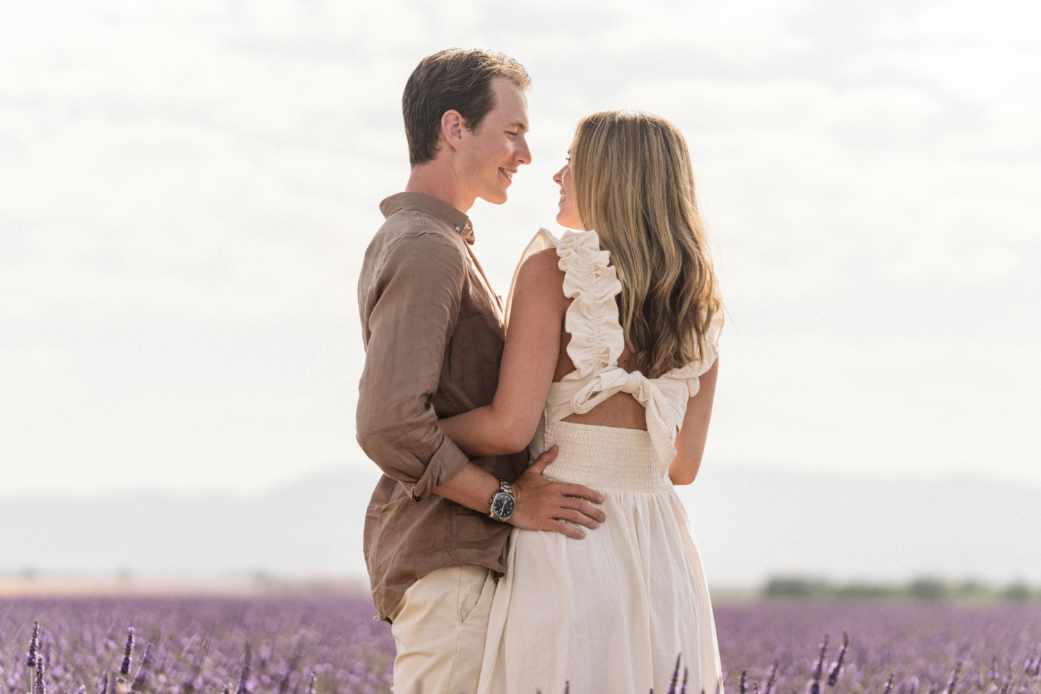 beautiful couple smile at each other in lavender field