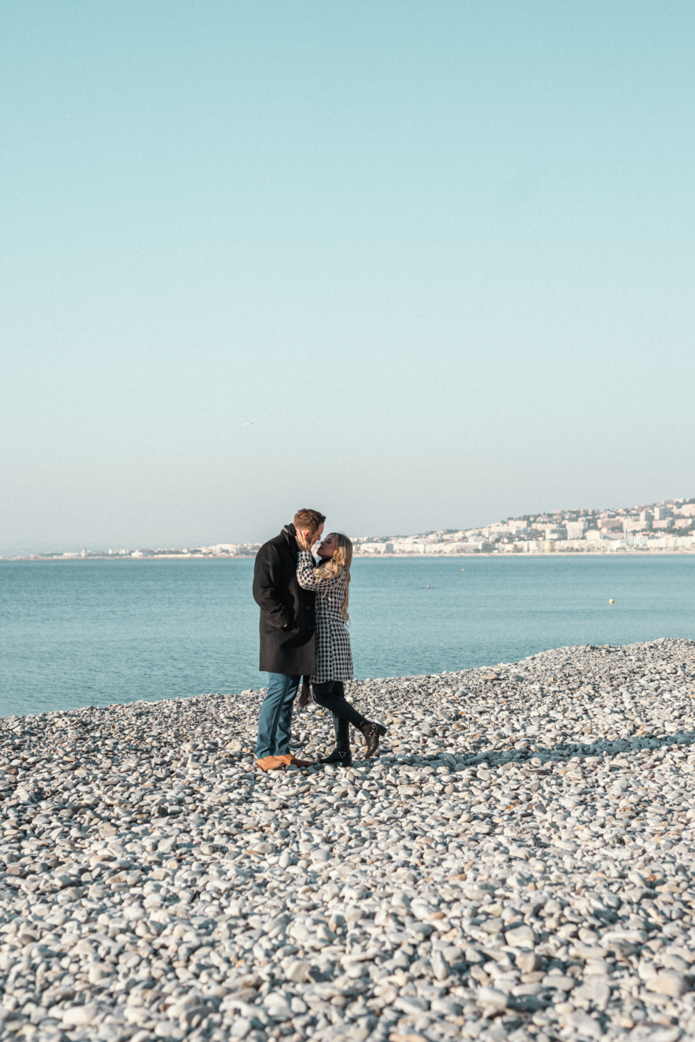 newlywed couple embrace on beach in nice france