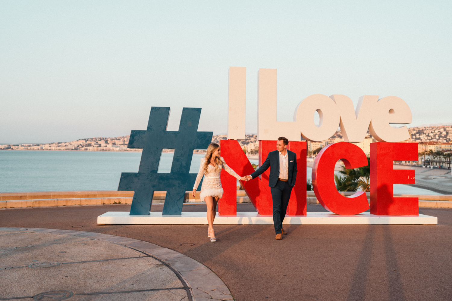 couple walking in front of i love nice sign in nice france