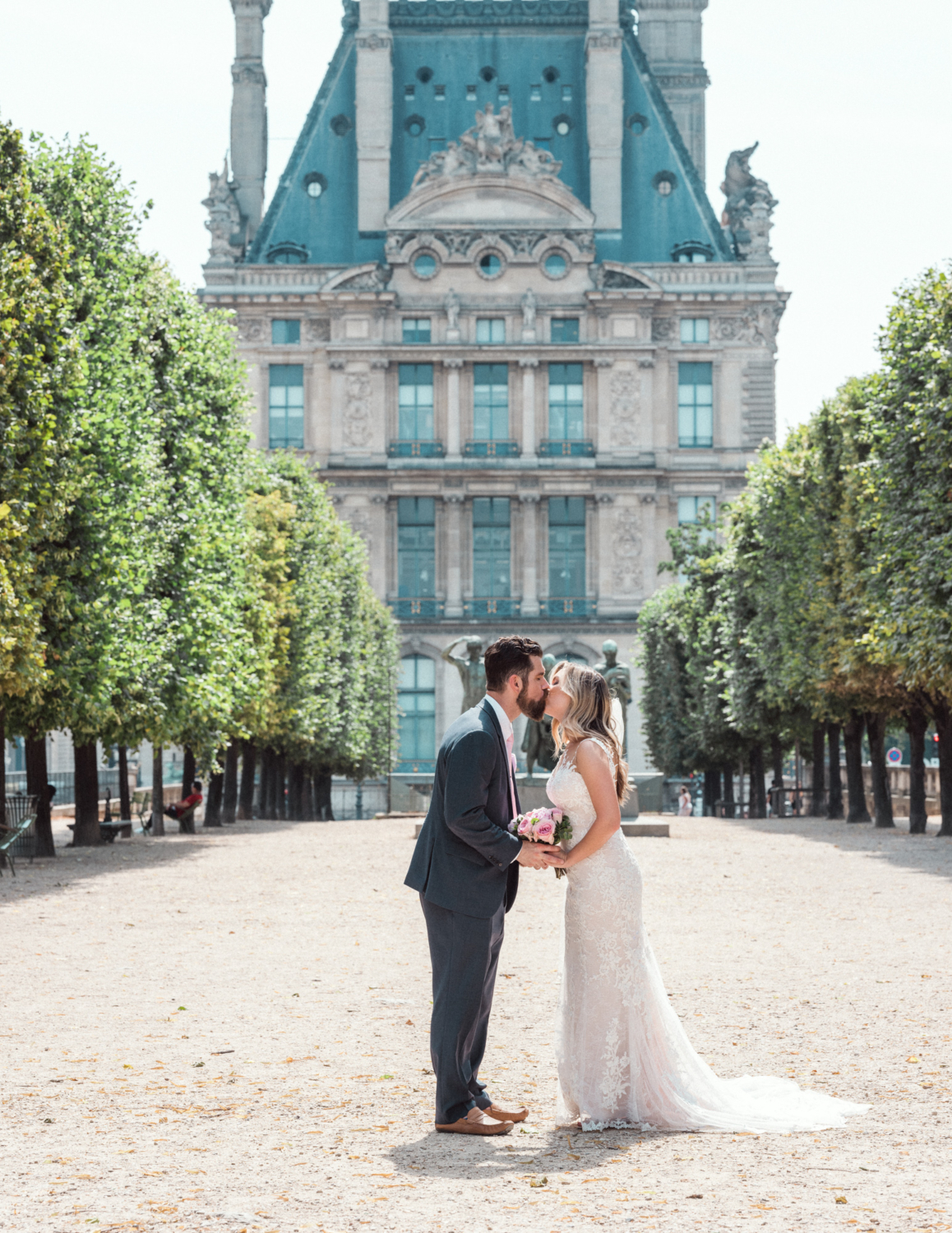 bride and groom kiss in tuileries gardens paris