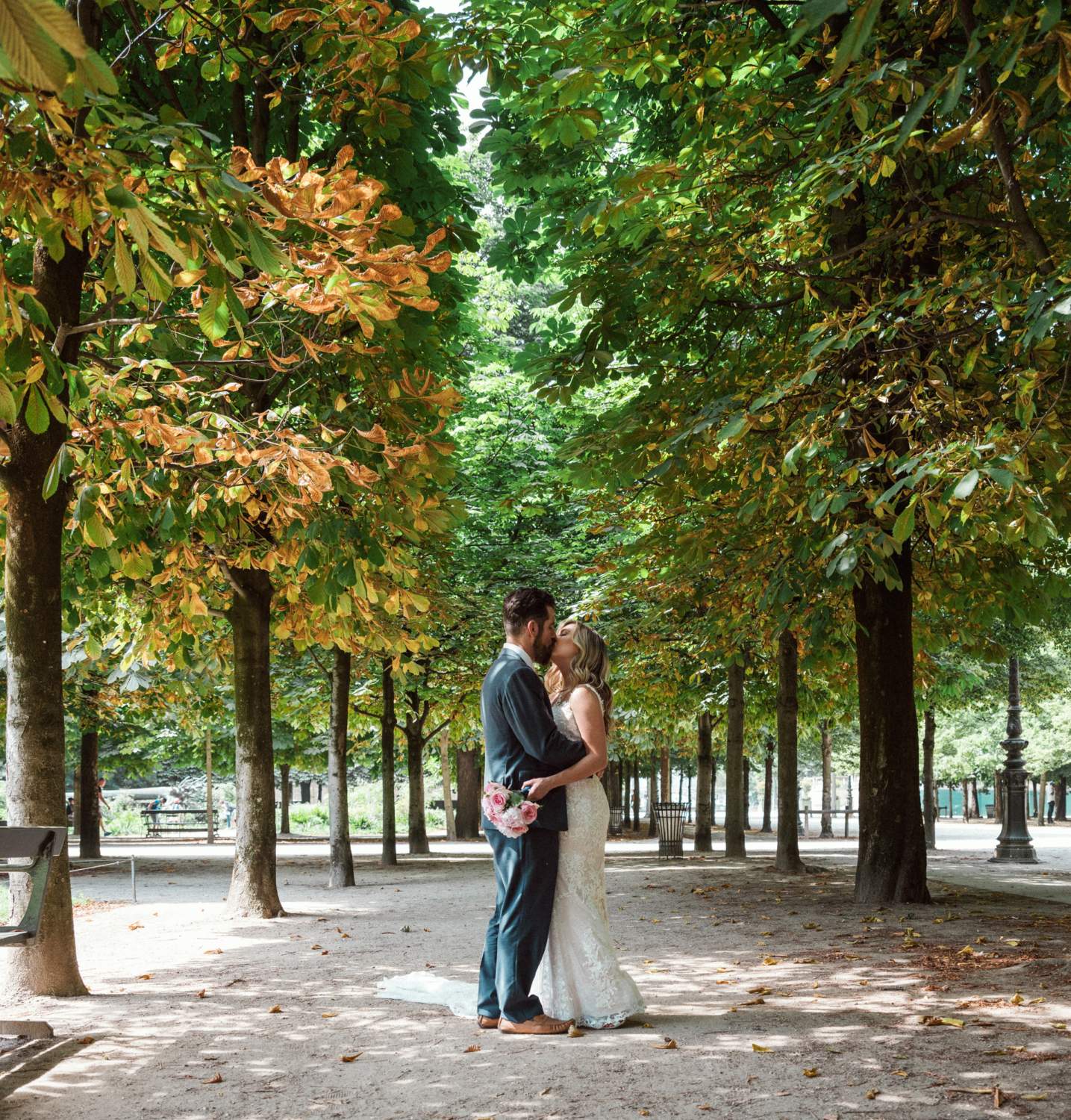 bride and groom kiss in tuileries gardens paris france