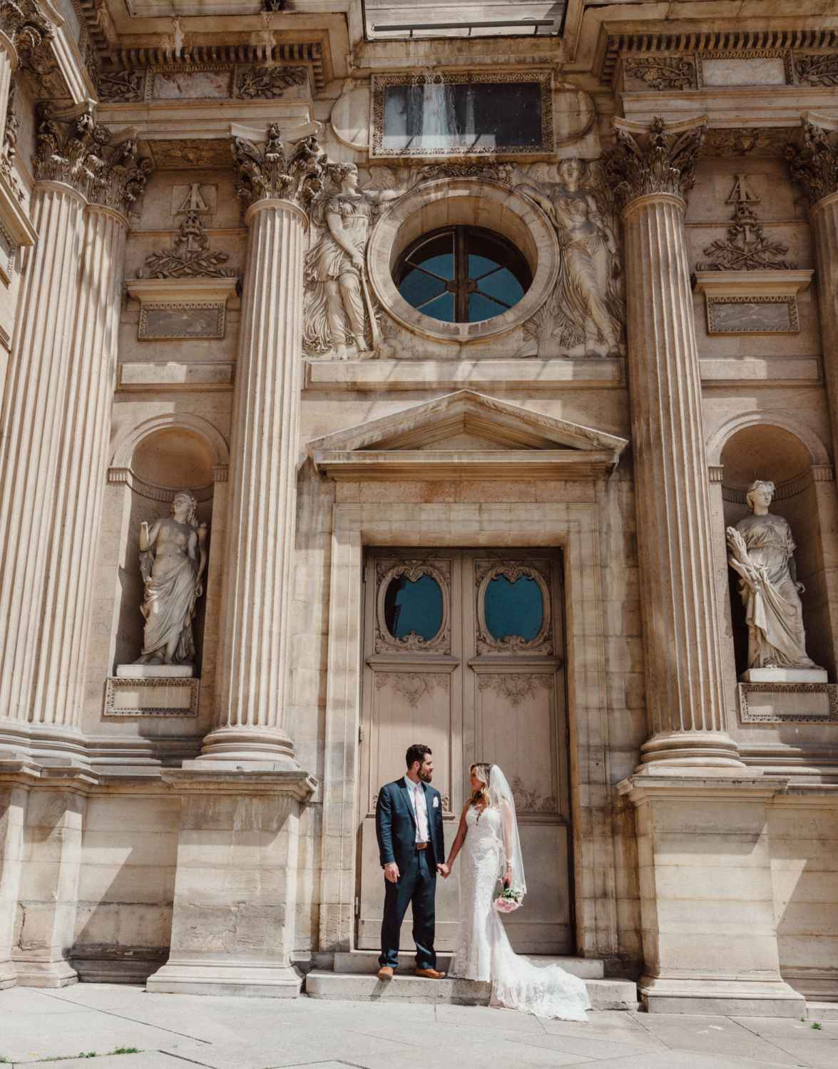 bride and groom pose at louvre museum paris