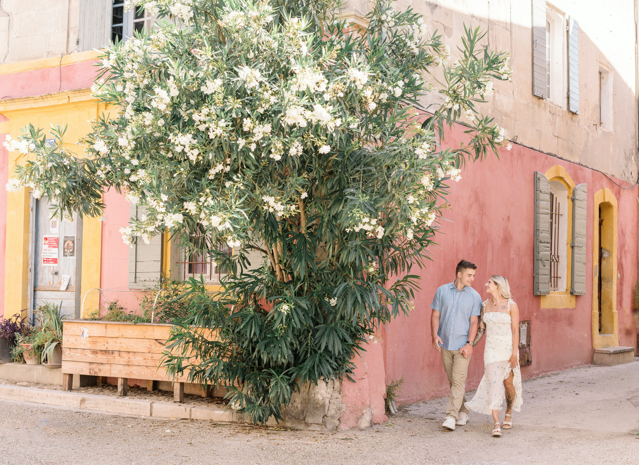 young engaged couple walk in colorful neighborhood in arles france