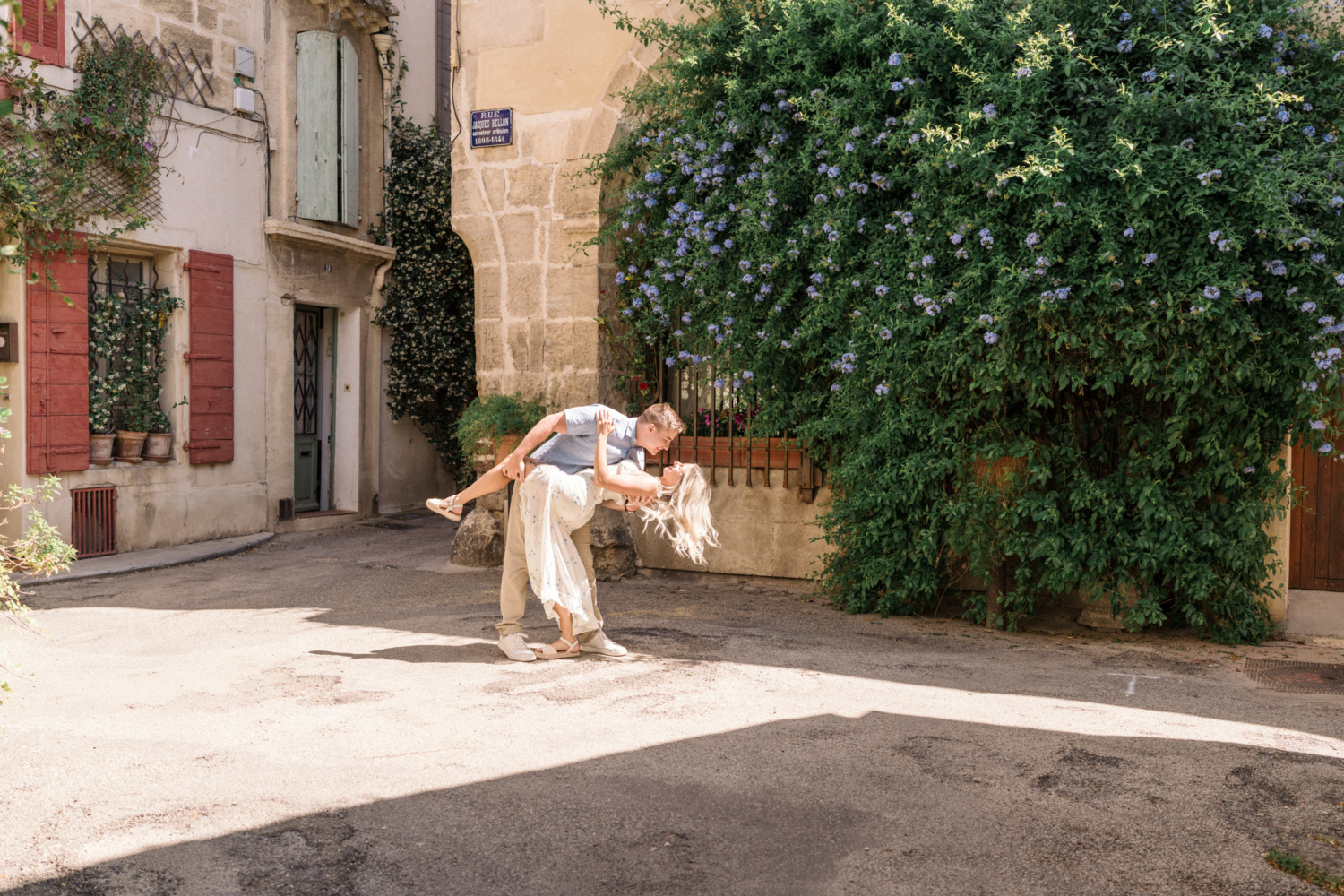 man dips woman backward in colorful courtyard in arles france