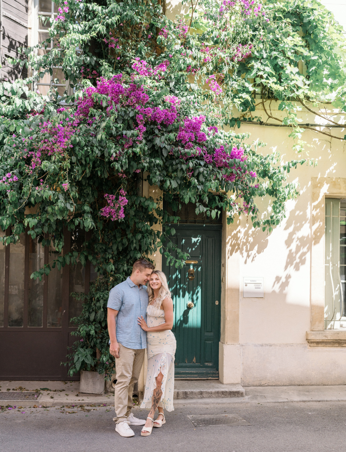 young engaged couple pose under bougainvillea tree in arles france