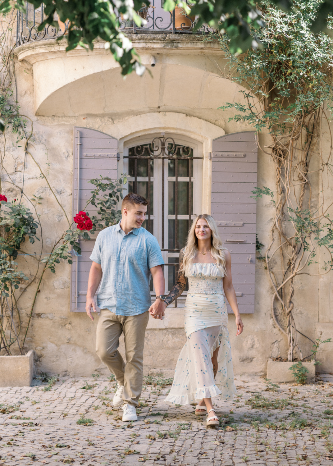 young engaged couple walk together in charming neighborhood in arles france