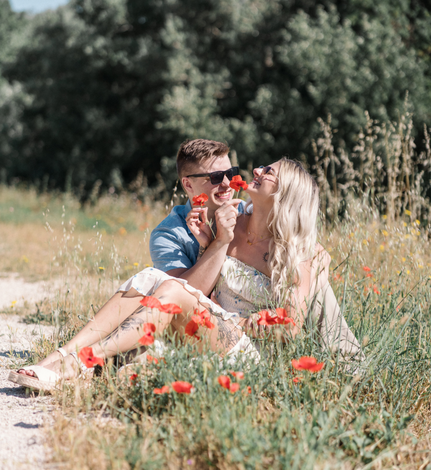 young engaged couple tickle each other with poppies in arles france