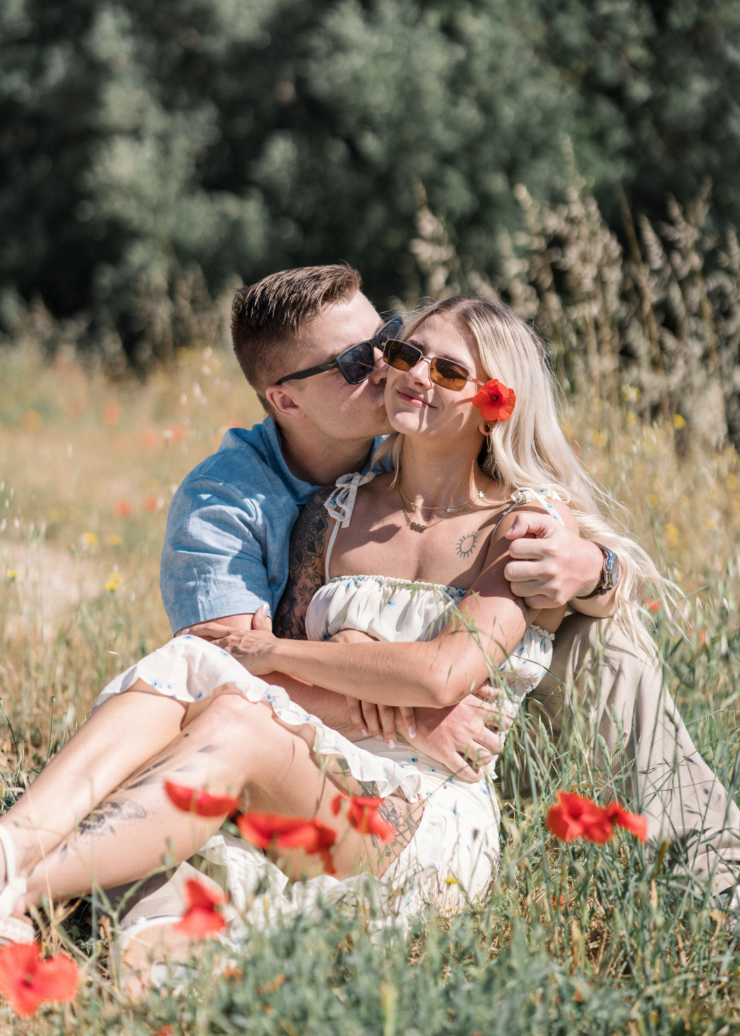 young engaged couple pose in a poppy field in arles france