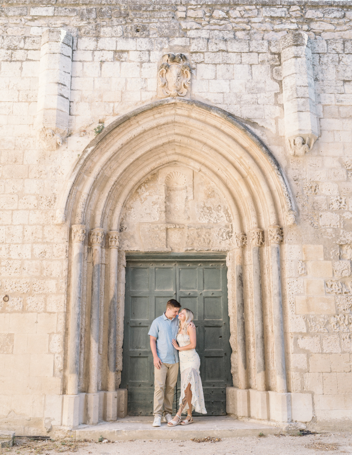 young engaged couple pose at saint trophime church in arles france