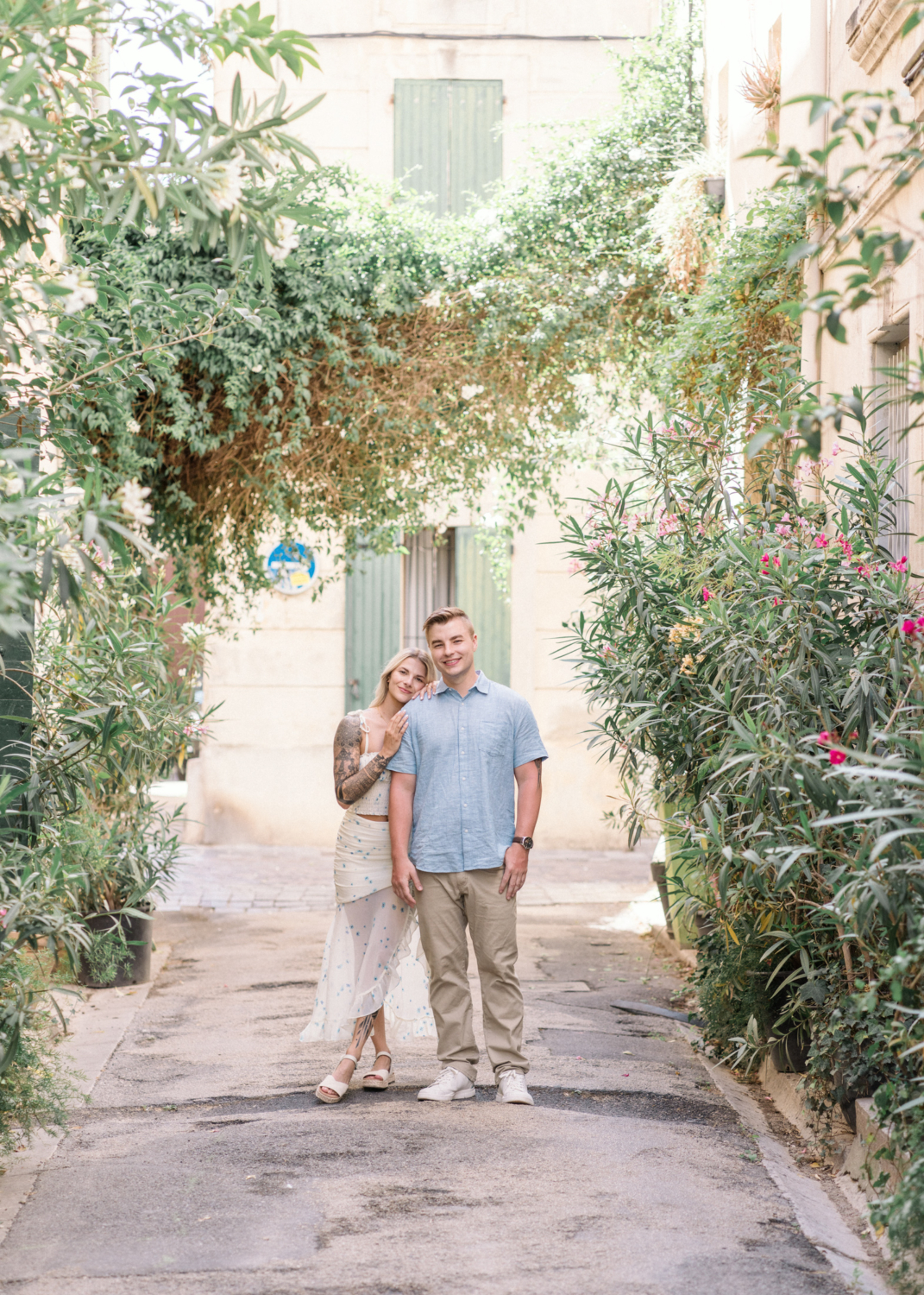 young engaged couple pose on colorful street in arles france