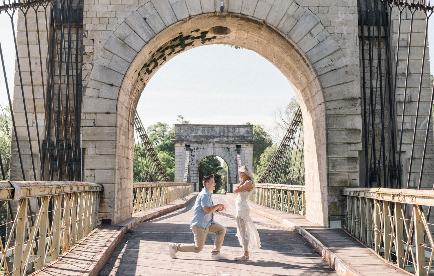 man presents engagement ring to woman on bridge in arles france