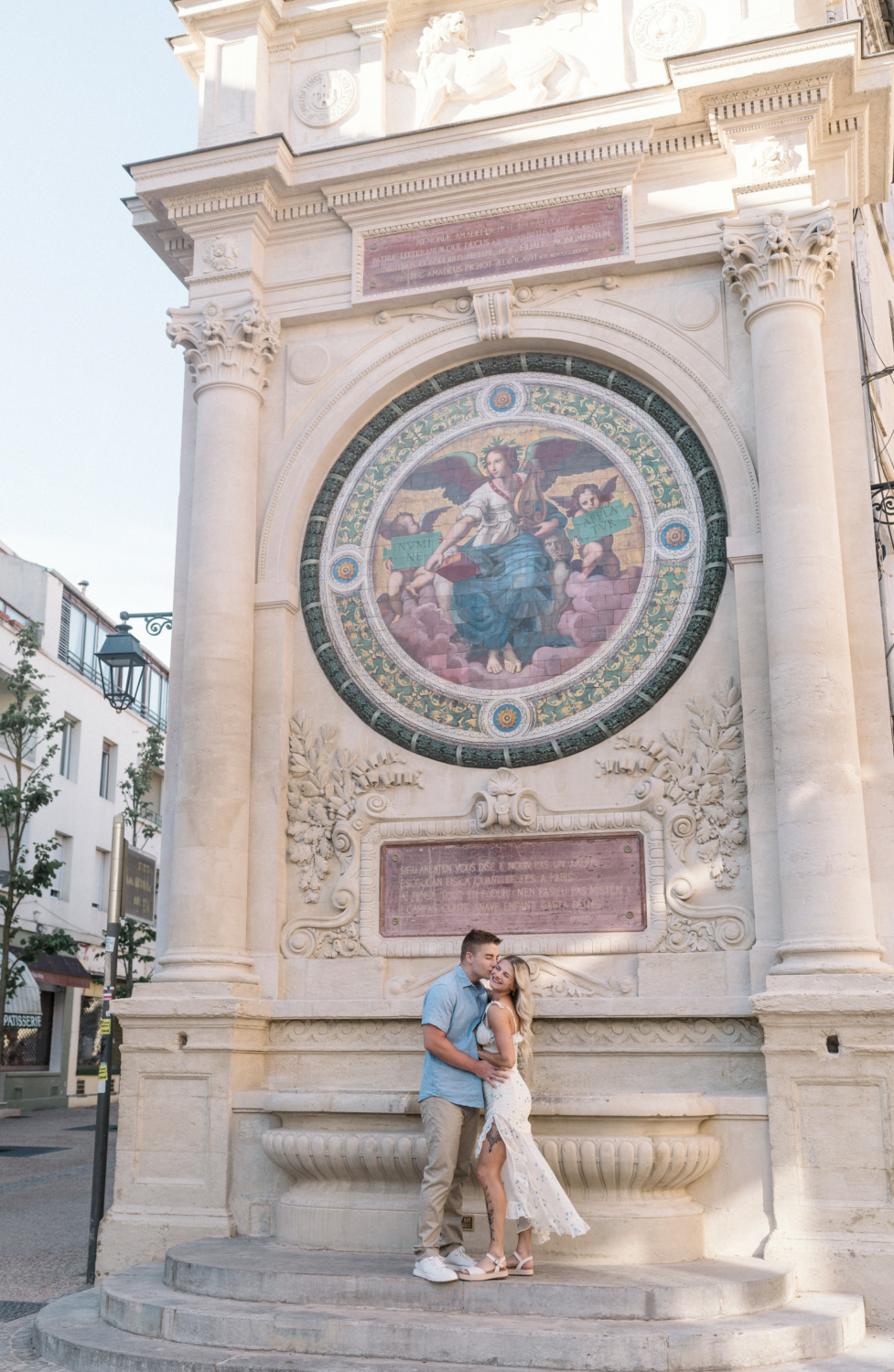 young engaged couple kiss a mosaic fountain in arles france