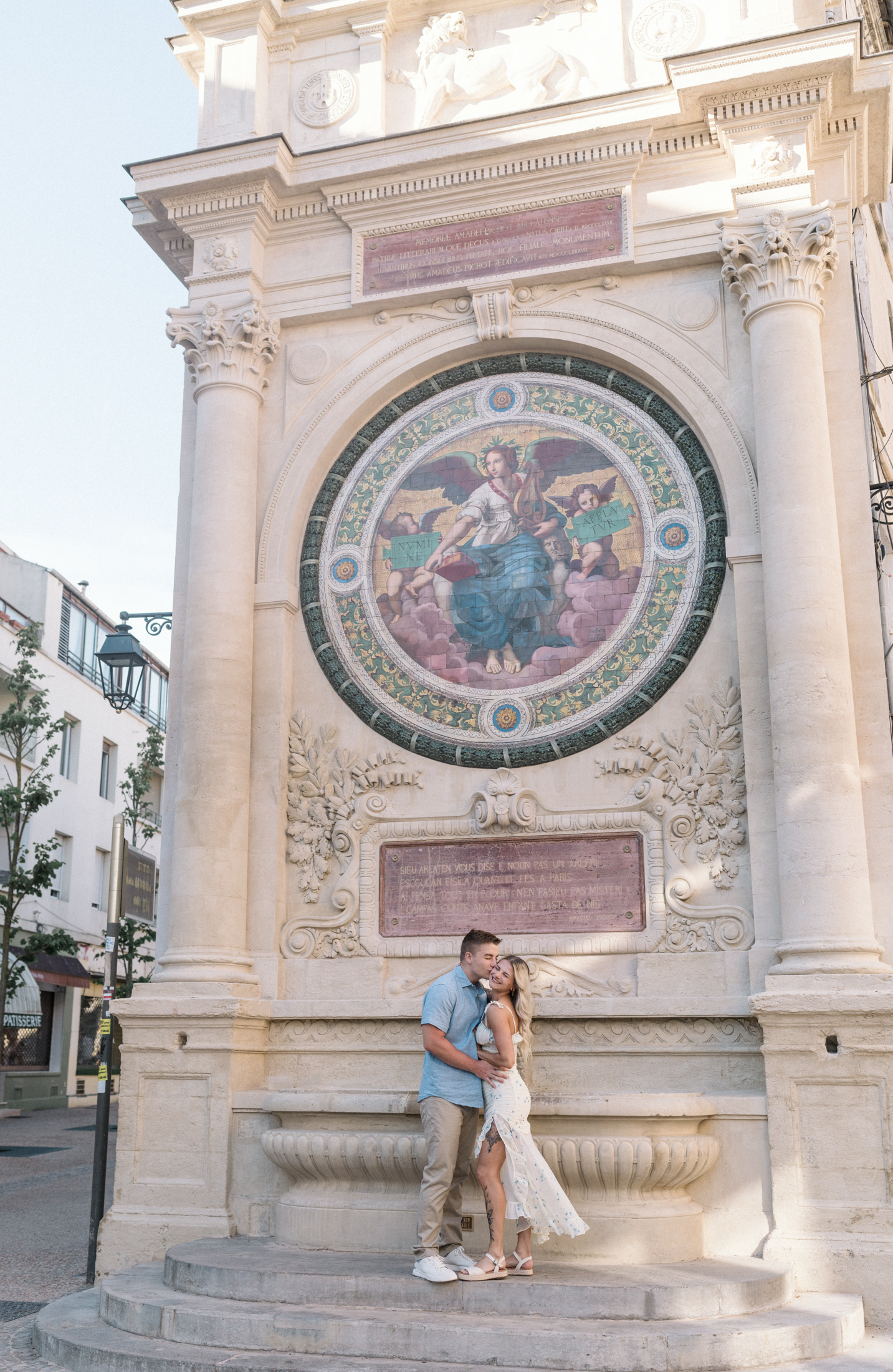 young engaged couple kiss a mosaic fountain in arles france during Engagement Photos In Provence