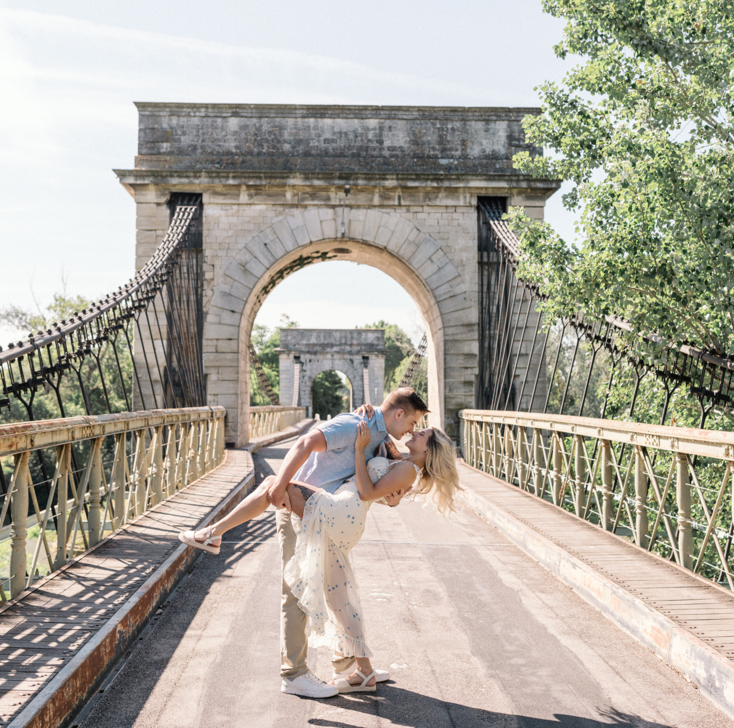 man dips woman on old stone bridge in arles france