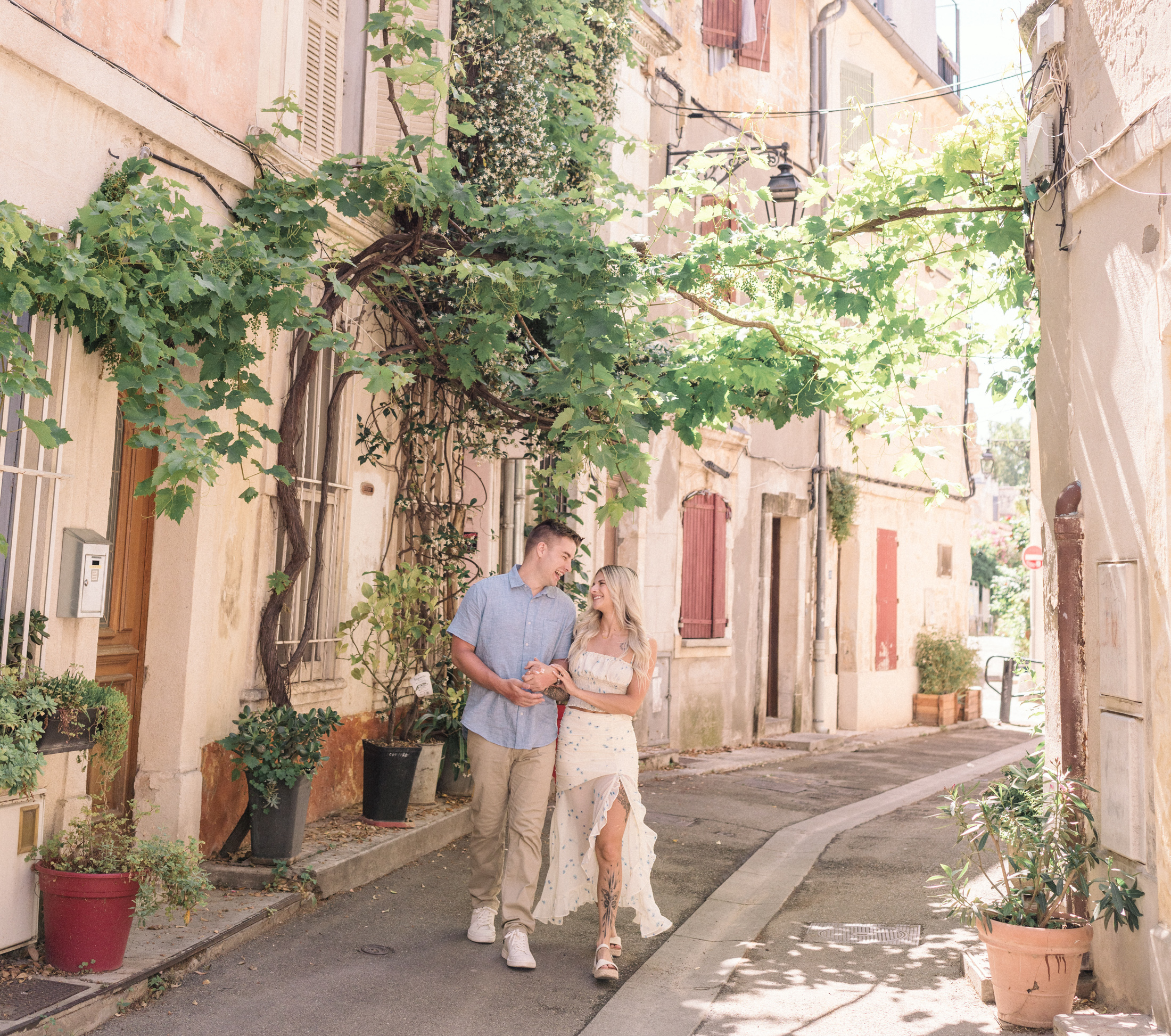 young engaged couple walk through la roquette neighborhood in arles france