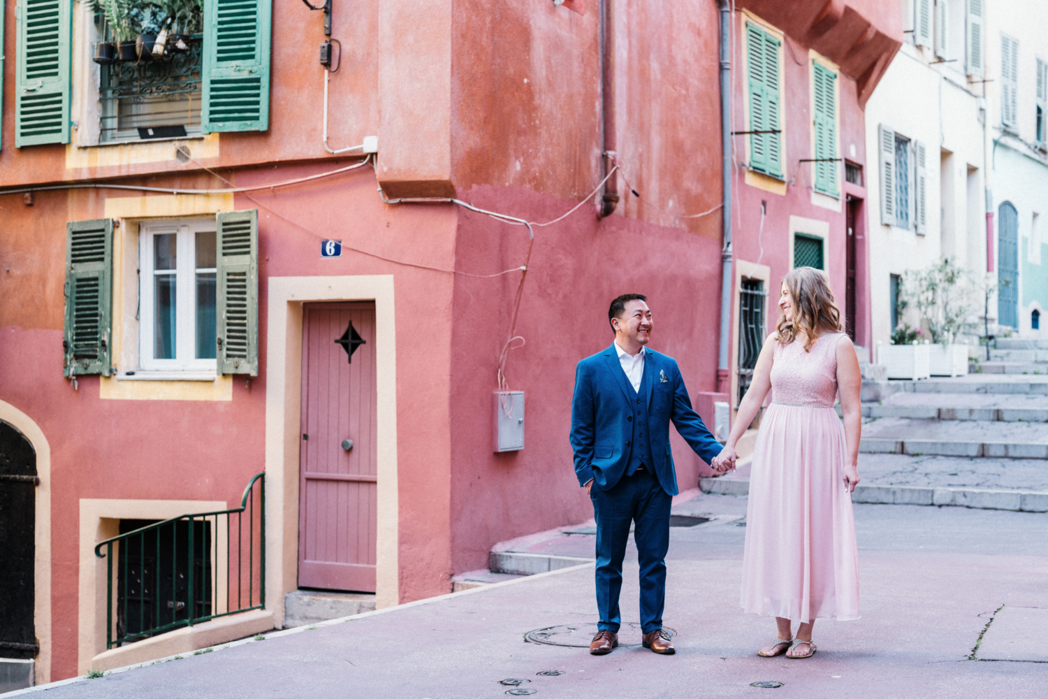 couple hold hands in old town in nice, france