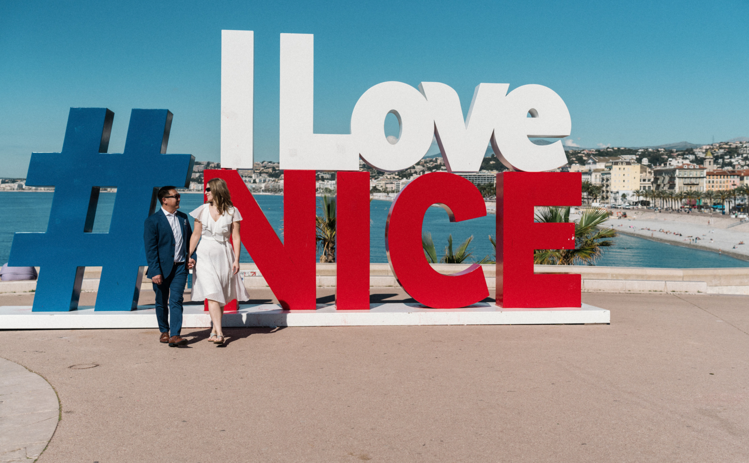 cool couple walk in front of the i love nice sign in nice, france