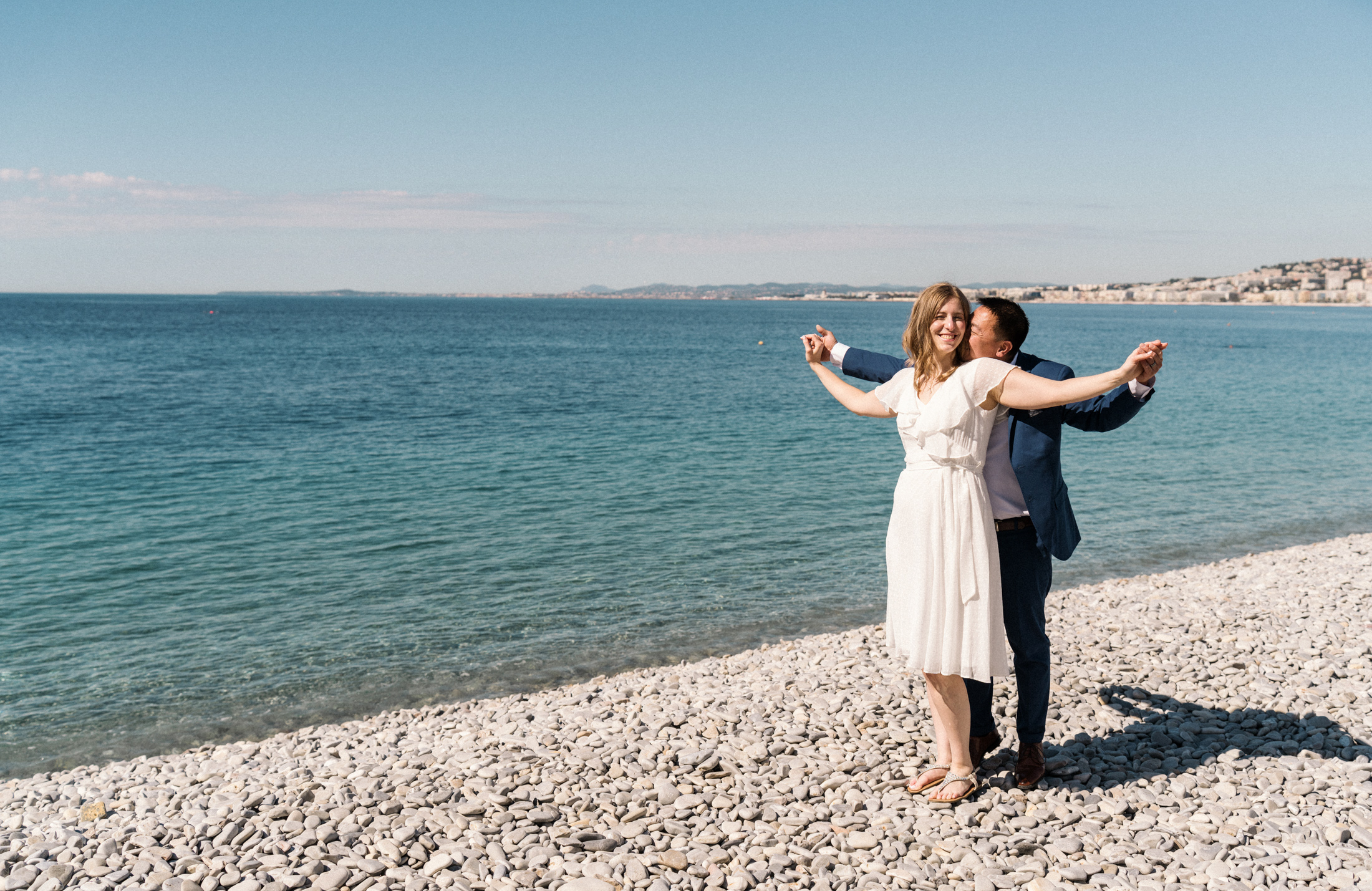 cute couple embrace on beach in nice, france