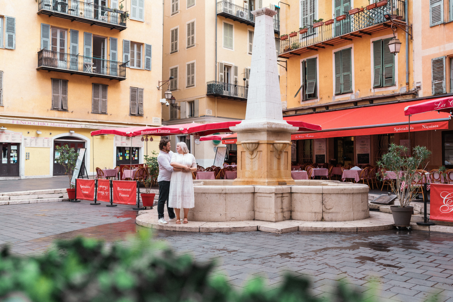 couple pose in front of fountain in nice france