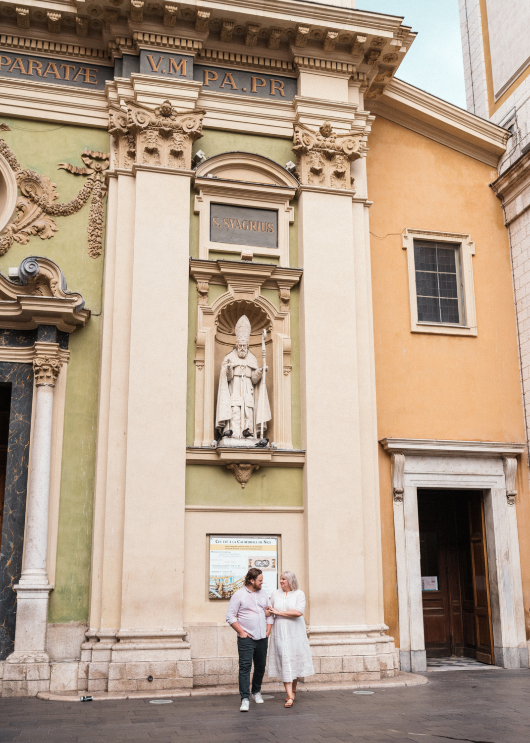 cute couple walk arm in arm in front of church in nice france