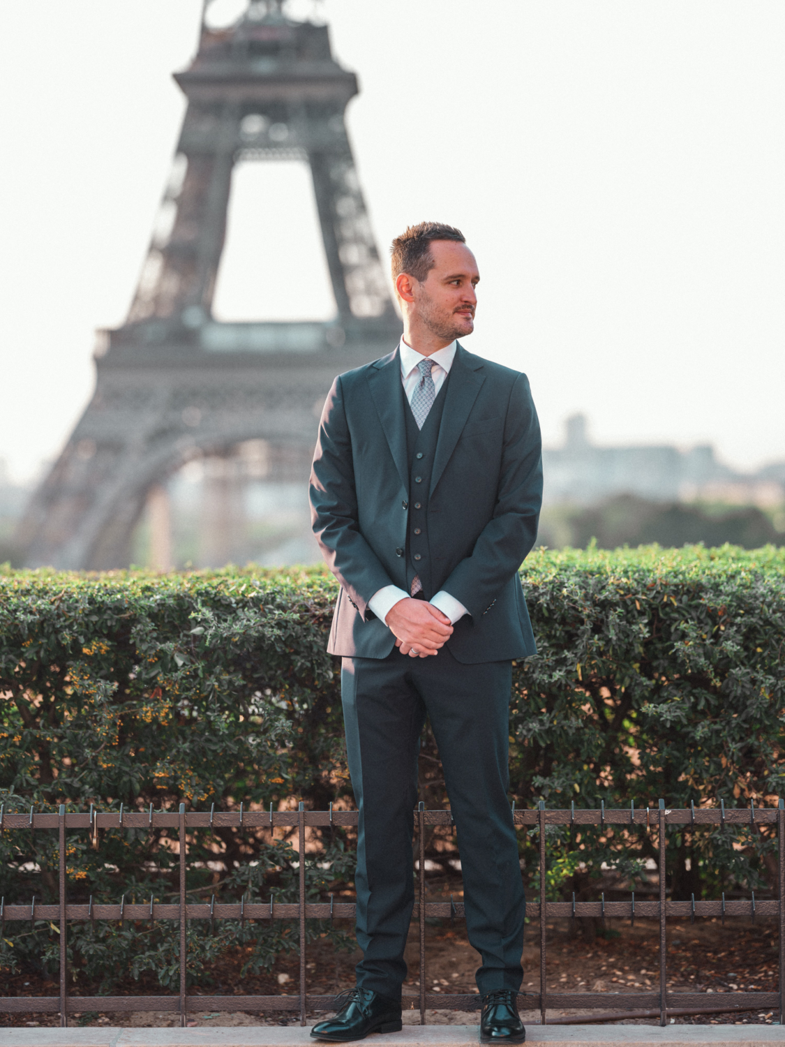 groom poses at eiffel tower paris