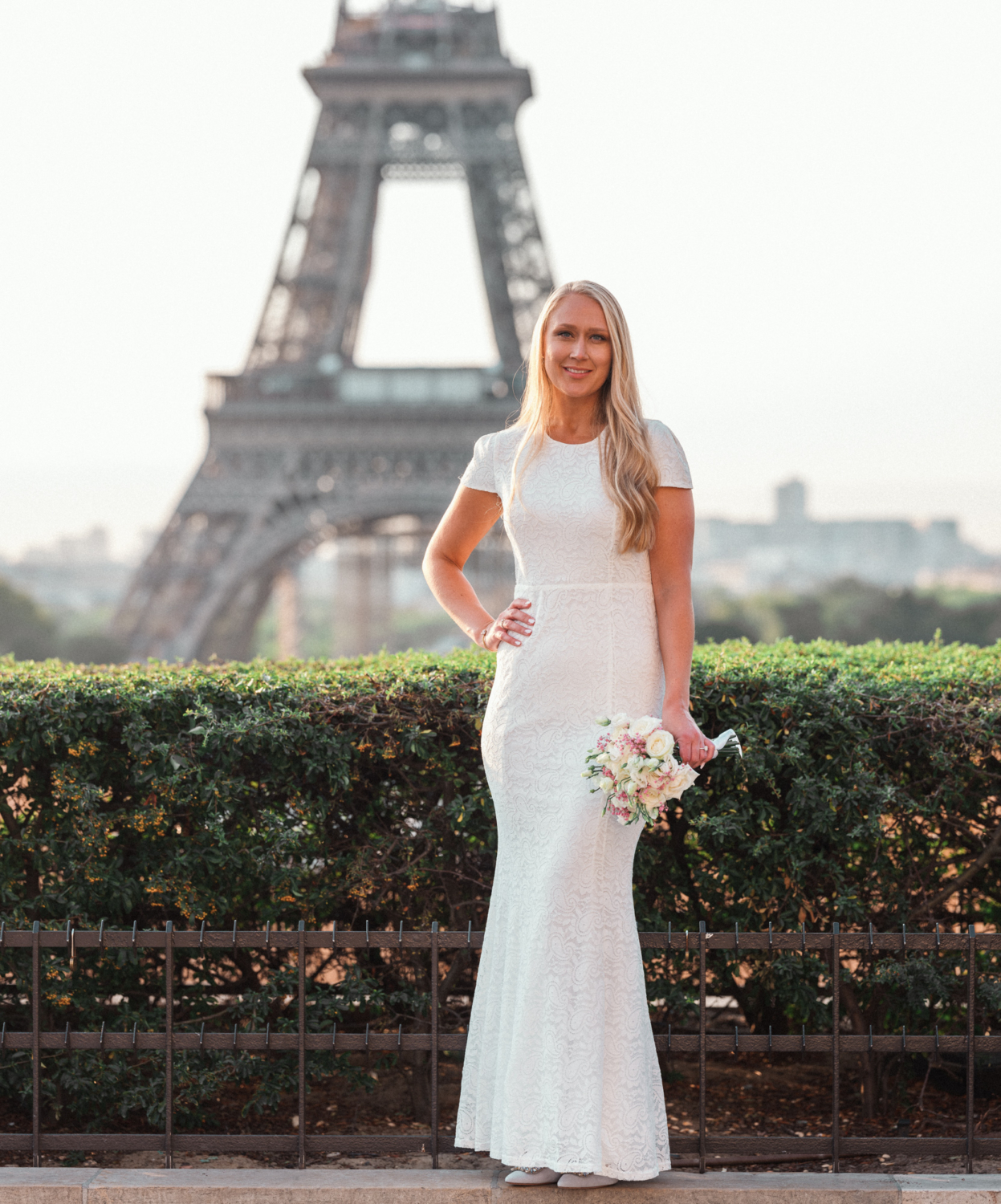 bride poses on her wedding day with view of eiffel tower