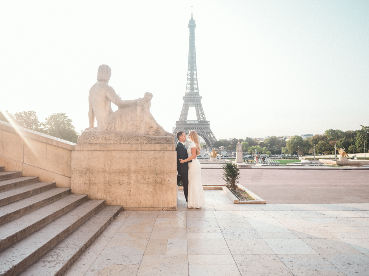 bride and groom embrace with view of eiffel tower in paris