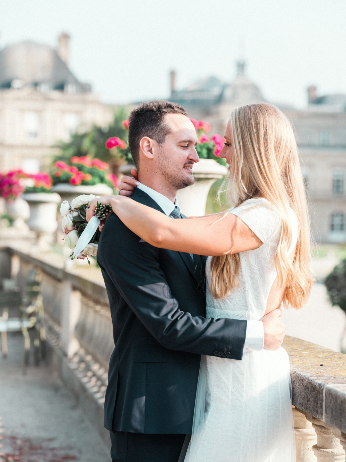 newlywed bride and groom embrace in garden in paris