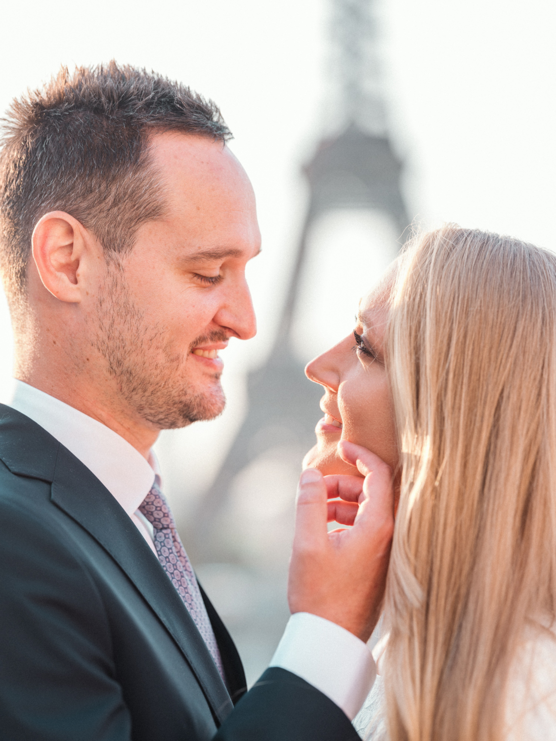 groom touches brides cheek on wedding day in paris
