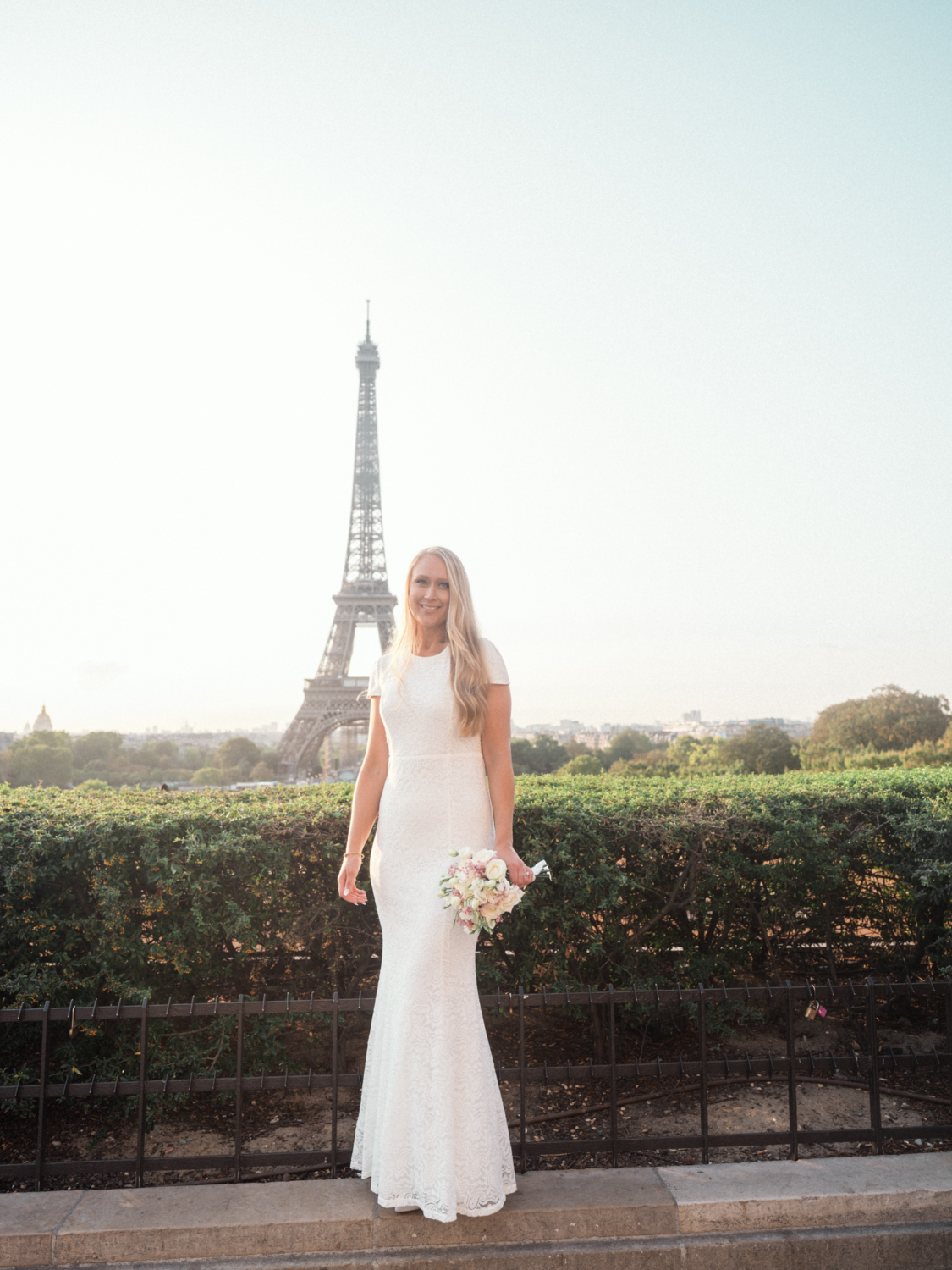 bride poses in front of eiffel tower on her wedding day